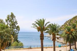 a view of a beach with palm trees and the ocean at Luxury Seaview Apartment Con Vista in Loutraki
