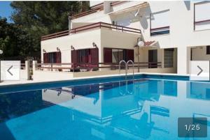 a swimming pool in front of a house at Casa da Piscina in Sesimbra