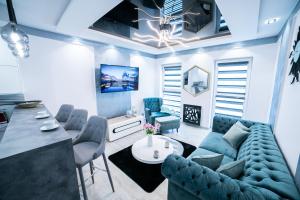 a living room with a blue couch and chairs at Markiz Apartments in Toruń