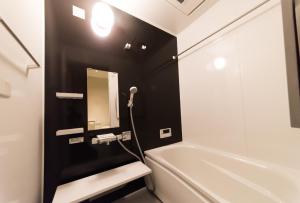 a bathroom with a white tub and a sink and a mirror at Umenotoan Gojyomibukawa in Kyoto +17 photos