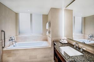 a bathroom with a tub, sink, and mirror at InterContinental Boston, an IHG Hotel in Boston