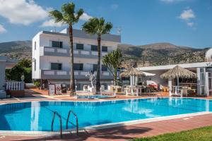 a swimming pool in front of a hotel with palm trees at I Candy Malia by Estia in Malia