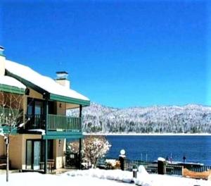 a building with snow on it next to a lake at Lagonita Lodge in Big Bear Lake