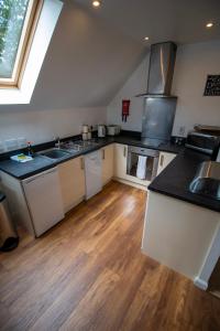 a kitchen with white cabinets and a wooden floor at Inchmarlo Golf Resort, Banchory Villa 26 AS 00266F in Banchory