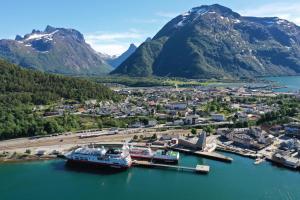 a group of boats docked in a harbor with mountains at Åndalsnes Sentrum Apartment No1 in Åndalsnes