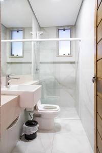 uma casa de banho branca com um WC e um lavatório em ESPAÇO 250 - Apto mobiliado, 3 quartos, sendo uma suíte, banheiro social, cozinha completa, sala de estar, ar condicionado, tv e internet em Tiradentes