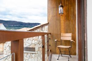 a chair sitting on the balcony of a house at ESPAÇO 250 - Apto mobiliado, 3 quartos, sendo uma suíte, banheiro social, cozinha completa, sala de estar, ar condicionado, tv e internet in Tiradentes