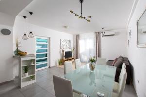 a dining room and living room with a glass table at Apartment Antoni 2 in Podstrana