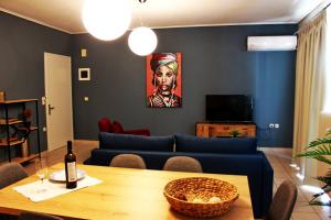 a living room with a blue couch and a table at Vallia Suites - Double suite B1 in Nafpaktos