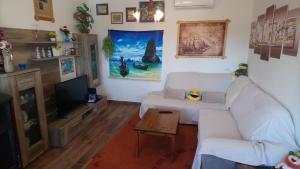 a living room with a white couch and a tv at Casa Bozzero in Krnica