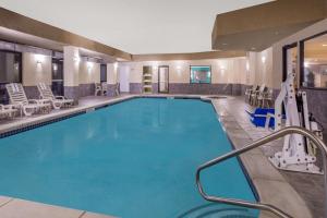 uma piscina num quarto de hotel com cadeiras e mesas em Wingate by Wyndham Athens GA em Athens