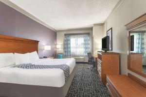 a hotel room with a bed and a flat screen tv at La Quinta Inn & Suites by Wyndham Jackson Airport - Pearl in Pearl