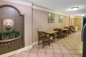 a room with a table and chairs and a clock on the wall at La Quinta Inn by Wyndham San Antonio Market Square in San Antonio