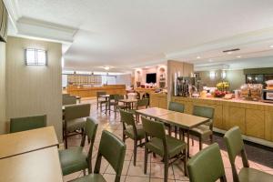 a restaurant with tables and chairs and a kitchen at La Quinta Inn by Wyndham San Antonio Market Square in San Antonio