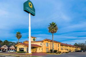 una señal para un hotel frente a un edificio en La Quinta Inn by Wyndham Lufkin, en Lufkin