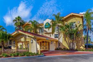 a building with palm trees in front of it at La Quinta Inn by Wyndham Tampa Bay Pinellas Park Clearwater in Pinellas Park