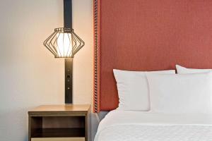 a bedroom with a bed and a lamp next to a table at La Quinta by Wyndham San Francisco Airport North in South San Francisco