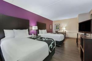 um quarto de hotel com duas camas e uma televisão de ecrã plano em La Quinta Inn by Wyndham Miami Airport North em Miami