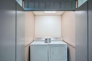 eine kleine Waschküche mit Waschmaschine und Trockner in der Unterkunft Wingate by Wyndham Memphis East in Memphis