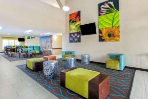 - une salle d'attente avec des chaises et des tables colorées dans l'établissement La Quinta Inn by Wyndham Moss Point - Pascagoula, à Moss Point