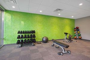 a gym with a green wall and some exercise equipment at La Quinta by Wyndham Rancho Cordova Sacramento in Rancho Cordova