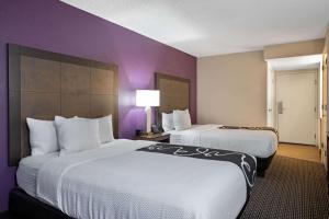 two beds in a hotel room with purple walls at La Quinta by Wyndham Rancho Cordova Sacramento in Rancho Cordova +26 photos