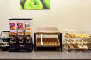 a counter with various types of pastries and an apple at La Quinta by Wyndham Stamford / New York City in Stamford