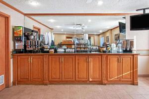 a kitchen with wooden cabinets and a food counter at La Quinta by Wyndham Albuquerque Journal Ctr NW in Albuquerque