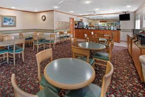 un ristorante con tavoli e sedie e un bar di La Quinta by Wyndham Albuquerque Journal Ctr NW ad Albuquerque