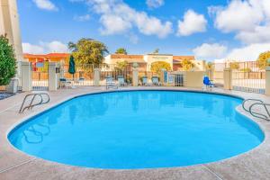 une grande piscine avec des chaises et une clôture dans l'établissement La Quinta Inn & Suites by Wyndham Las Cruces Organ Mountain, à Las Cruces