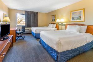 um quarto de hotel com duas camas e uma secretária e uma televisão em La Quinta Inn & Suites by Wyndham Las Cruces Organ Mountain em Las Cruces