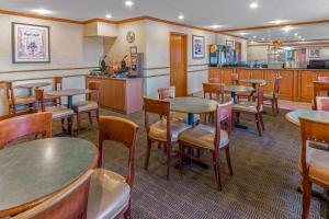 a restaurant with tables and chairs and a kitchen at La Quinta Inn & Suites by Wyndham Las Cruces Organ Mountain in Las Cruces