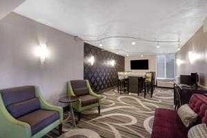 a waiting room with chairs and a table and a television at La Quinta Inn by Wyndham Binghamton - Johnson City in Johnson City