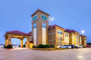 een groot gebouw met een klokkentoren op een parkeerplaats bij La Quinta by Wyndham Longview North in Longview