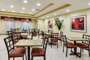 - un restaurant avec des tables, des chaises et des fleurs sur le mur dans l'établissement La Quinta by Wyndham Canton MS, à Canton