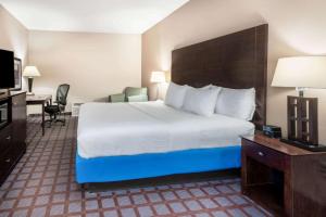 a hotel room with a bed, desk and a television at La Quinta by Wyndham Bozeman in Bozeman