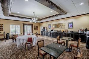 a dining room with a table and chairs and a kitchen at La Quinta by Wyndham Vicksburg in Vicksburg