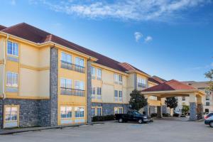 a building with a car parked in a parking lot at La Quinta by Wyndham Conway in Conway