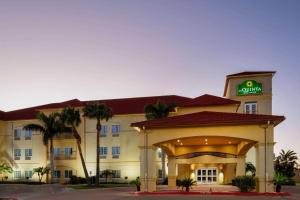 a hotel with a sign on the front of it at La Quinta Inn Suites by Wyndham Raymondville Harlingen in Raymondville