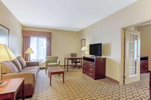 a hotel room with a couch and a television at La Quinta by Wyndham Lancaster in Ronks