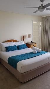 a bedroom with a large bed with a blue blanket at Beaconlea in Gold Coast