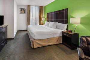 een hotelkamer met een groot bed en een televisie bij La Quinta by Wyndham Puebla Palmas Angelopolis in Puebla