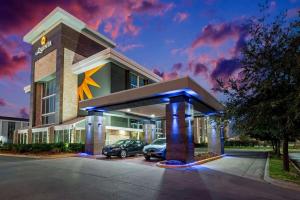 a building with a car parked in front of it at La Quinta by Wyndham Dallas I-35 Walnut Hill Ln in Oldham