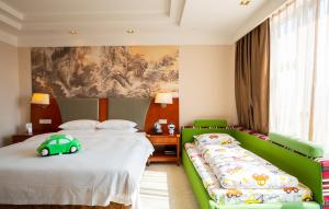 a bedroom with two beds and a green couch at Jinhai New Century Grand Hotel Ninghai in Ninghai