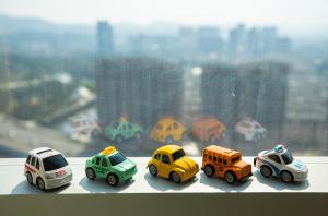 a group of toy cars sitting on a window sill at Jinhai New Century Grand Hotel Ninghai in Ninghai