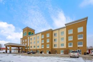 a large yellow building with a clock tower in a parking lot at La Quinta by Wyndham Dickinson in Dickinson