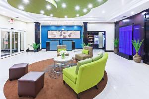 a living room with green chairs and a table at La Quinta by Wyndham Marshall in Marshall