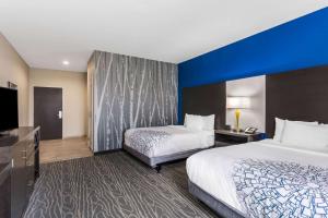 a hotel room with two beds and a flat screen tv at La Quinta by Wyndham Odessa North - Sienna Tower in Odessa +28 photos
