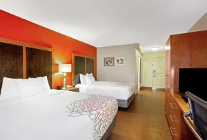 um quarto de hotel com duas camas e uma televisão de ecrã plano em La Quinta by Wyndham Williamsburg Historic Area em Williamsburg
