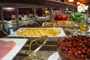 un buffet con dos bandejas de comida en un mostrador en Dostar Hotel en Aktau